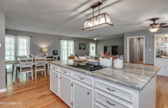 kitchen with white cabinetry, a wealth of natural light, and black electric cooktop