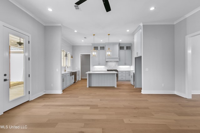 kitchen with a ceiling fan, visible vents, light countertops, hanging light fixtures, and a center island