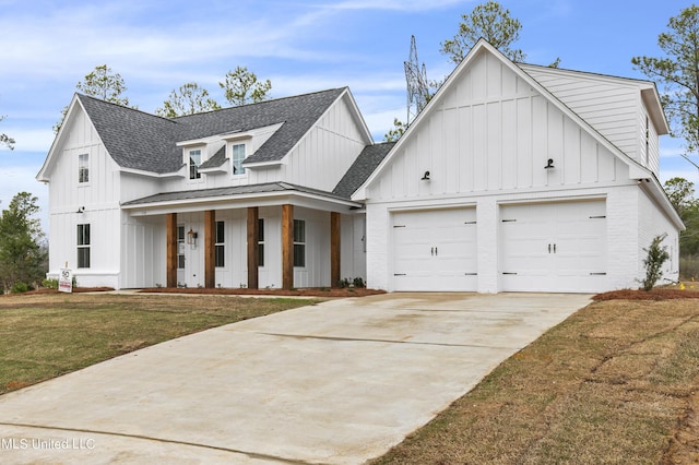 modern farmhouse featuring an attached garage, covered porch, roof with shingles, a front lawn, and board and batten siding