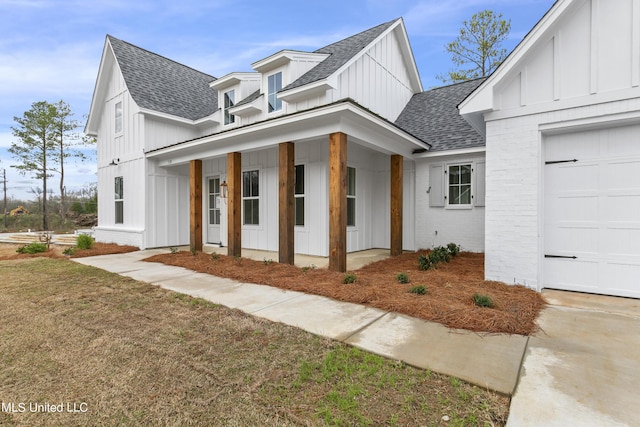 view of front of property featuring a front lawn, a porch, board and batten siding, and roof with shingles