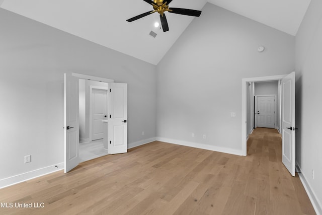 unfurnished bedroom featuring light wood-style flooring, high vaulted ceiling, ceiling fan, and baseboards