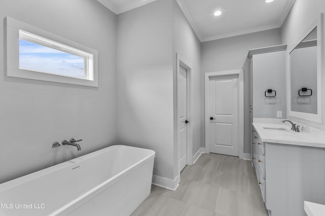 bathroom with recessed lighting, a soaking tub, ornamental molding, vanity, and baseboards