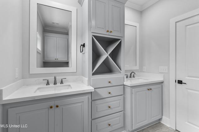 bathroom featuring crown molding, two vanities, and a sink