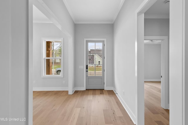 entryway with ornamental molding, light wood-style floors, and baseboards