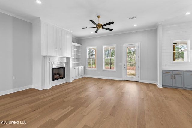 unfurnished living room with visible vents, crown molding, and a premium fireplace