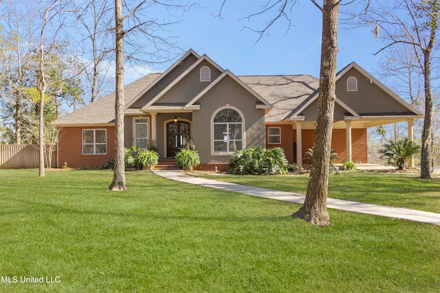 view of front of house with a front yard, brick siding, and stucco siding