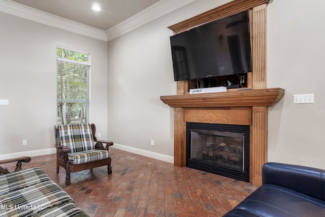 living room with brick floor, baseboards, a glass covered fireplace, and ornamental molding