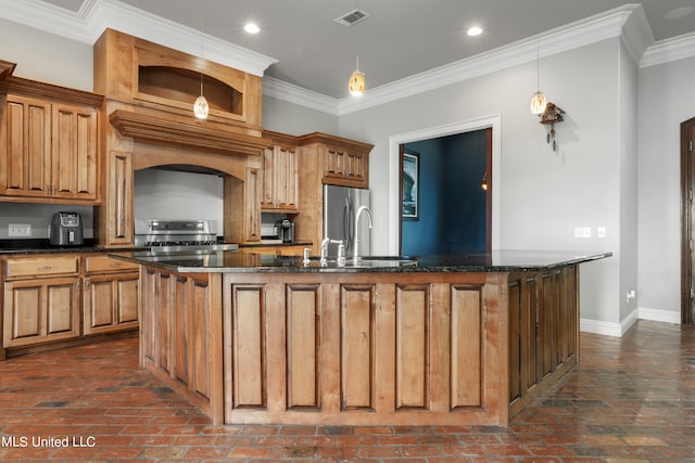 kitchen with stove, visible vents, baseboards, a center island with sink, and crown molding