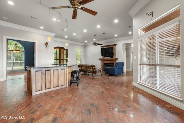 kitchen with plenty of natural light, ornamental molding, and open floor plan