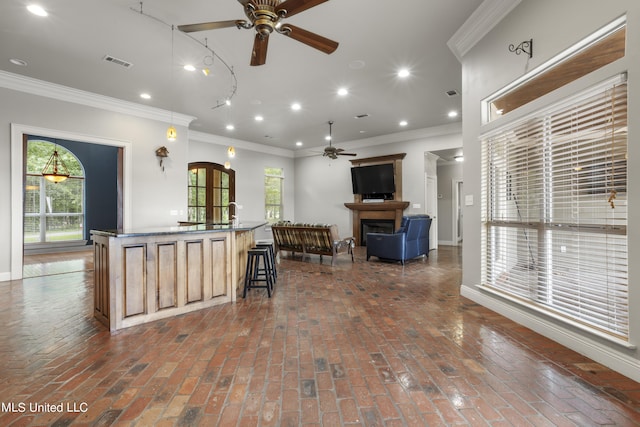 1400 Magnolia Bluff Dr, Gautier, MS 39553 - kitchen featuring ceiling fan, open floor plan, brick flooring, a center island with sink, and crown molding