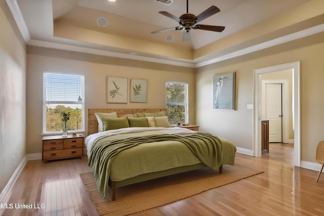 1400 Magnolia Bluff Dr, Gautier, MS 39553 - bedroom with multiple windows, a tray ceiling, and light wood finished floors