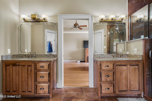 bathroom featuring a ceiling fan, two vanities, and a sink