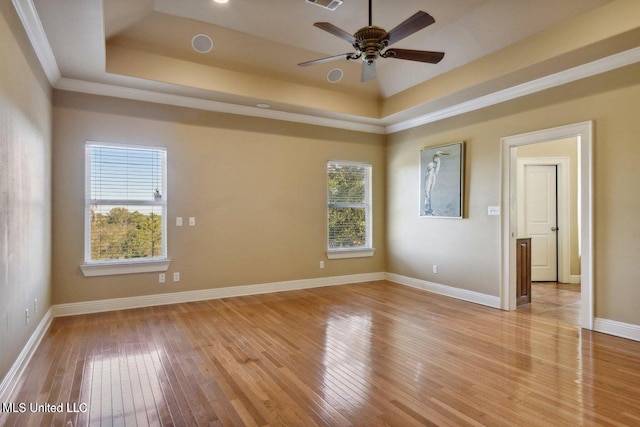 1400 Magnolia Bluff Dr, Gautier, MS 39553 - spare room featuring light wood-style floors, a raised ceiling, baseboards, and a ceiling fan