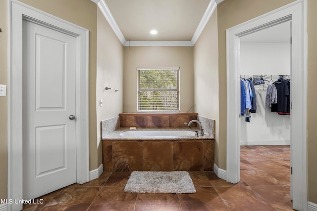 full bath featuring a garden tub, baseboards, ornamental molding, and a walk in closet