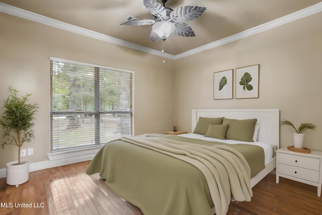 bedroom featuring crown molding, baseboards, ceiling fan, and wood finished floors