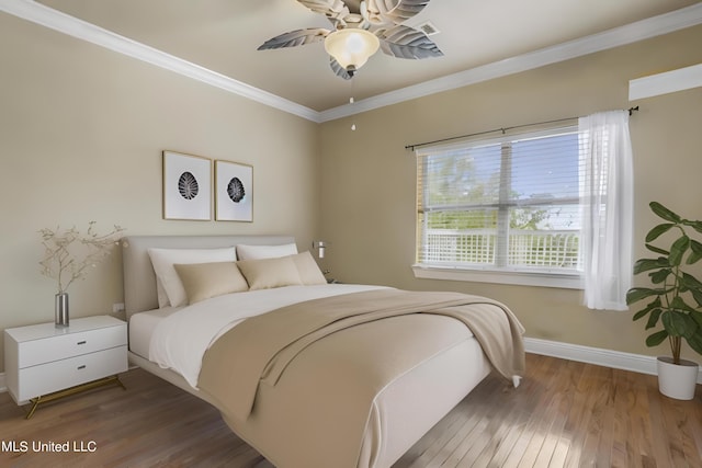 bedroom featuring ceiling fan, crown molding, baseboards, and wood finished floors