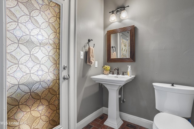1400 Magnolia Bluff Dr, Gautier, MS 39553 - bathroom with baseboards, brick flooring, and toilet