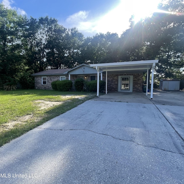 109 Evergreen Dr, Diberville, MS 39540 - ranch-style home with stone siding, concrete driveway, a front yard, and an attached carport