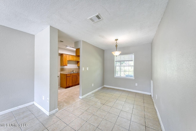 tiled empty room with sink and a textured ceiling