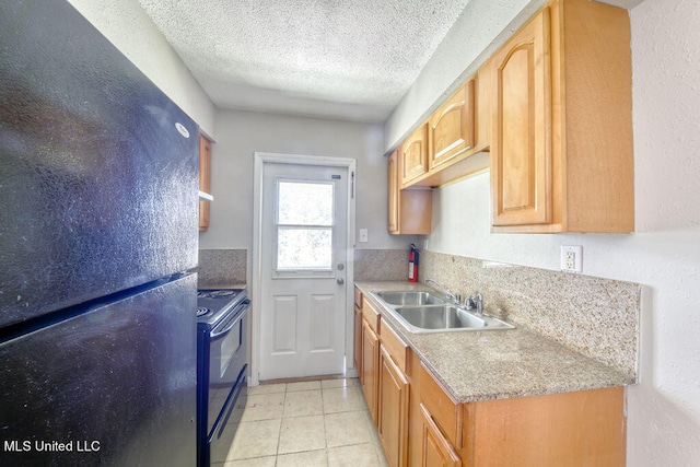 kitchen featuring sink, black appliances, light tile patterned floors, light brown cabinetry, and a textured ceiling