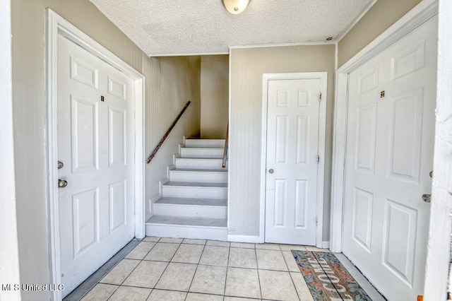 staircase featuring a textured ceiling and tile patterned floors