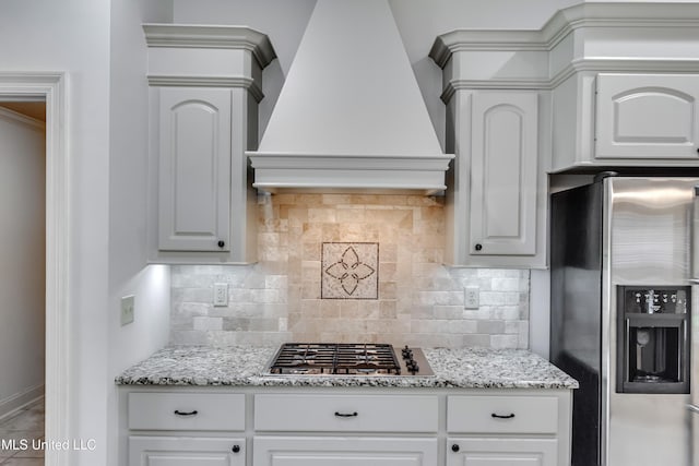 272 Hidden Hills Pkwy, Brandon, MS 39047 - kitchen featuring stainless steel appliances, custom range hood, tasteful backsplash, light stone counters, and white cabinetry