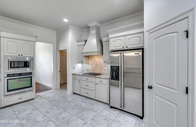 272 Hidden Hills Pkwy, Brandon, MS 39047 - kitchen featuring appliances with stainless steel finishes, custom range hood, tasteful backsplash, light stone countertops, and crown molding