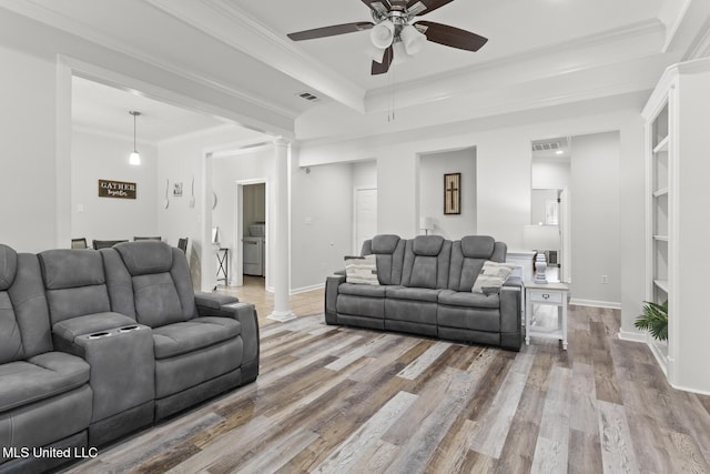 living room featuring decorative columns, wood finished floors, and visible vents