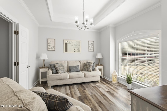 living area featuring an inviting chandelier, a raised ceiling, crown molding, and wood finished floors