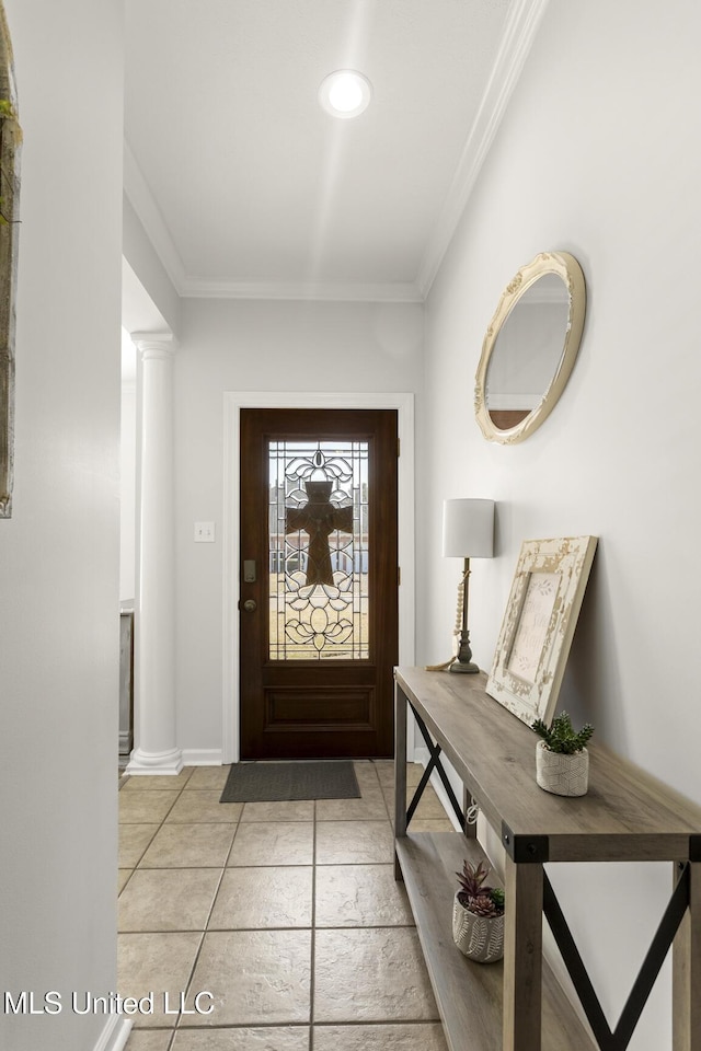 foyer featuring crown molding, baseboards, and ornate columns