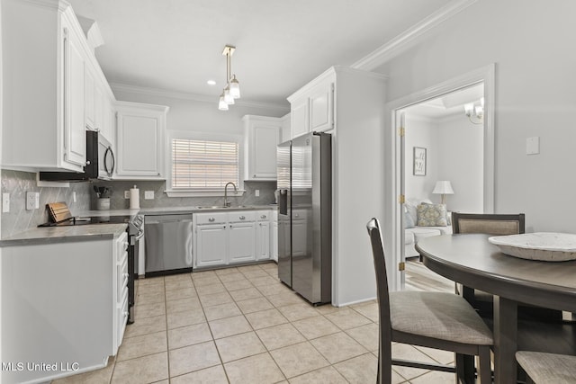 kitchen with white cabinets, appliances with stainless steel finishes, crown molding, and a sink