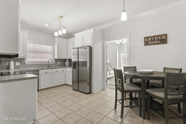 kitchen with white cabinets, stainless steel refrigerator with ice dispenser, backsplash, and a sink