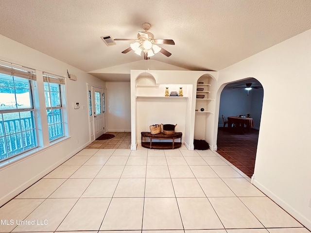 1154 E Old Pass Rd, Long Beach, MS 39560 - foyer with ceiling fan, lofted ceiling, light tile patterned flooring, a textured ceiling, and arched walkways