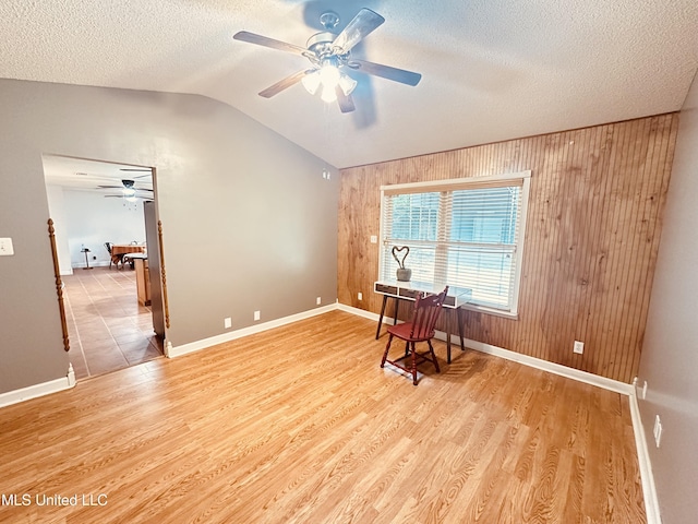1154 E Old Pass Rd, Long Beach, MS 39560 - unfurnished room with a ceiling fan, wood walls, vaulted ceiling, baseboards, and wood finished floors