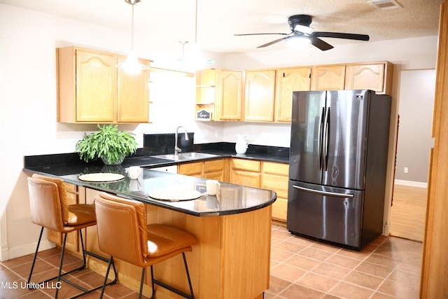 1154 E Old Pass Rd, Long Beach, MS 39560 - kitchen featuring freestanding refrigerator, a peninsula, dark countertops, a sink, and light brown cabinets