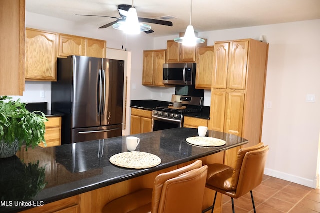 1154 E Old Pass Rd, Long Beach, MS 39560 - kitchen with appliances with stainless steel finishes, a breakfast bar, ceiling fan, light tile patterned flooring, and a peninsula