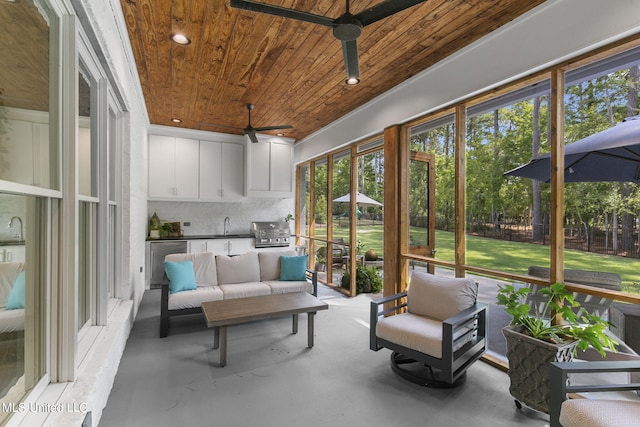 sunroom / solarium with sink, ceiling fan, and wood ceiling