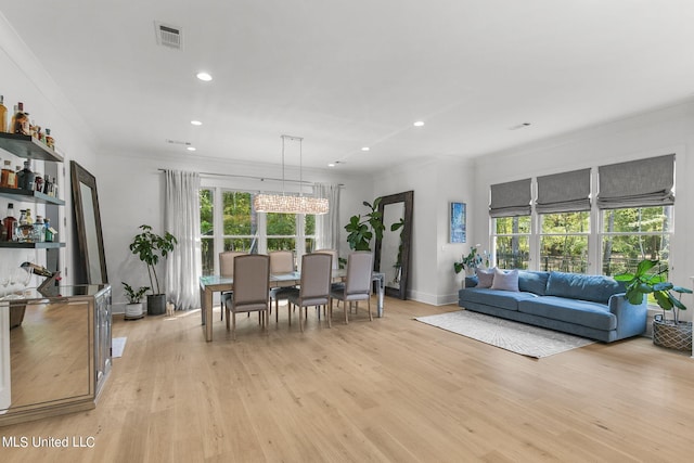 living room with light hardwood / wood-style flooring, plenty of natural light, and crown molding