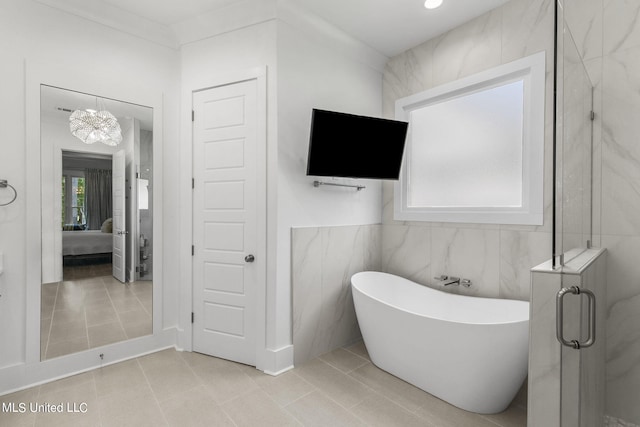 bathroom featuring tile patterned flooring, a notable chandelier, separate shower and tub, and tile walls