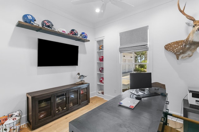 home office featuring built in shelves, light hardwood / wood-style floors, ceiling fan, and ornamental molding