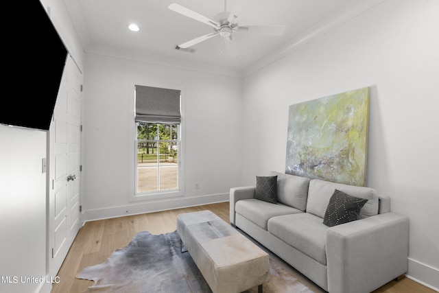 living room with ceiling fan, light wood-type flooring, and crown molding