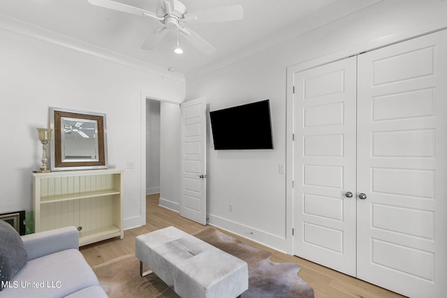 living room featuring hardwood / wood-style floors, ceiling fan, and ornamental molding