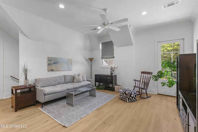 living room featuring ceiling fan, vaulted ceiling, ornamental molding, and light hardwood / wood-style flooring