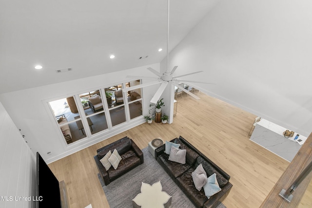 living room with hardwood / wood-style floors, ceiling fan, and lofted ceiling