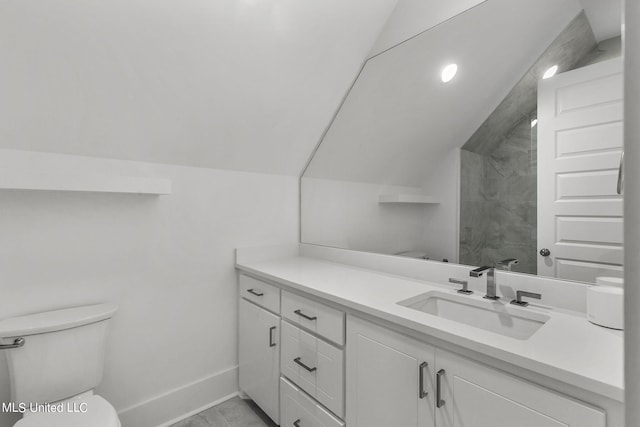 bathroom with toilet, a shower, vanity, and vaulted ceiling