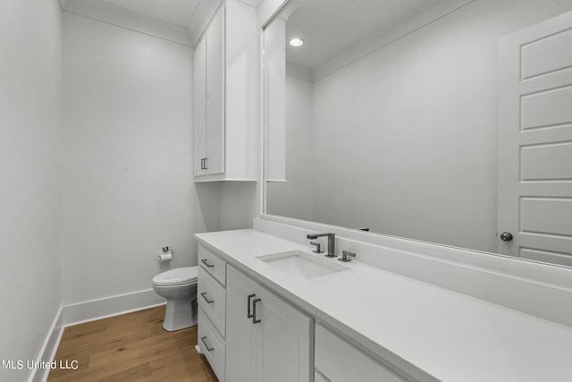 bathroom with toilet, vanity, and hardwood / wood-style flooring