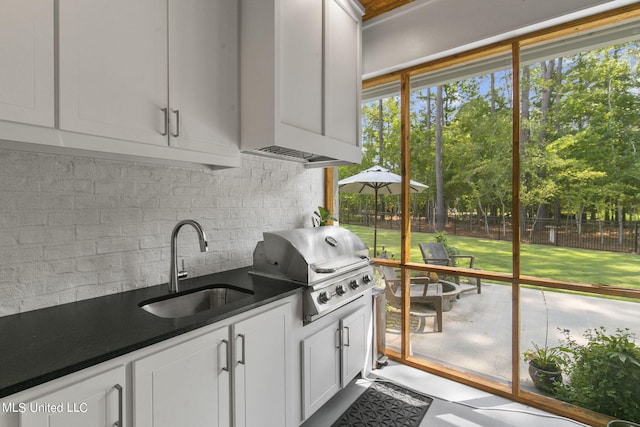 kitchen featuring backsplash, white cabinetry, and sink