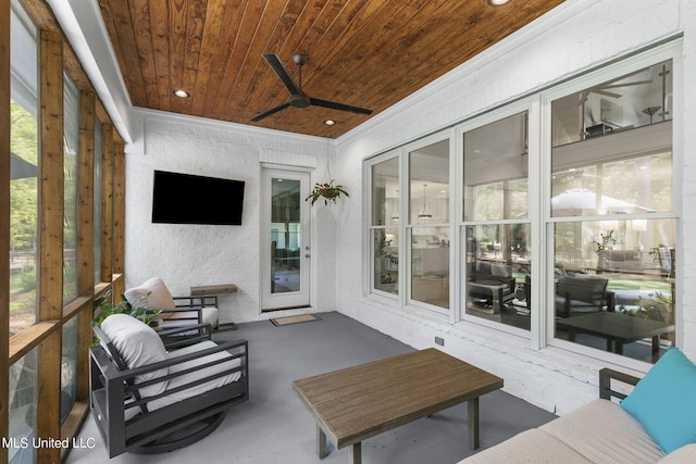 sunroom featuring ceiling fan and wood ceiling