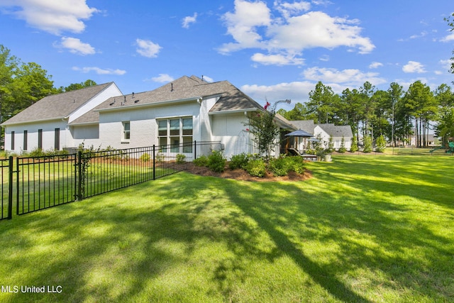 rear view of house featuring a lawn