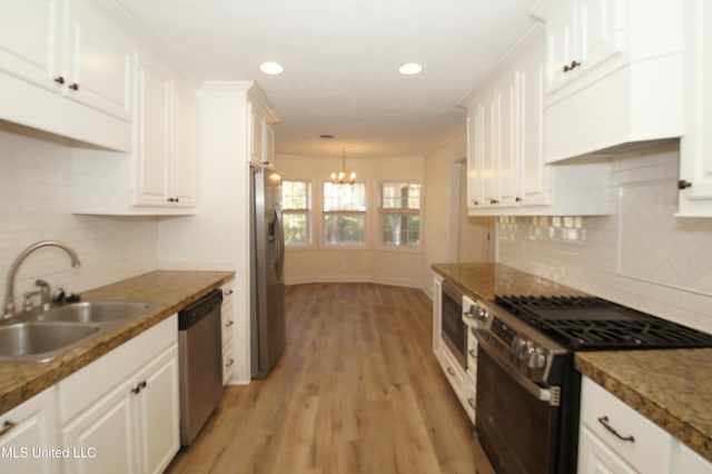 kitchen featuring sink, stainless steel appliances, backsplash, and white cabinetry